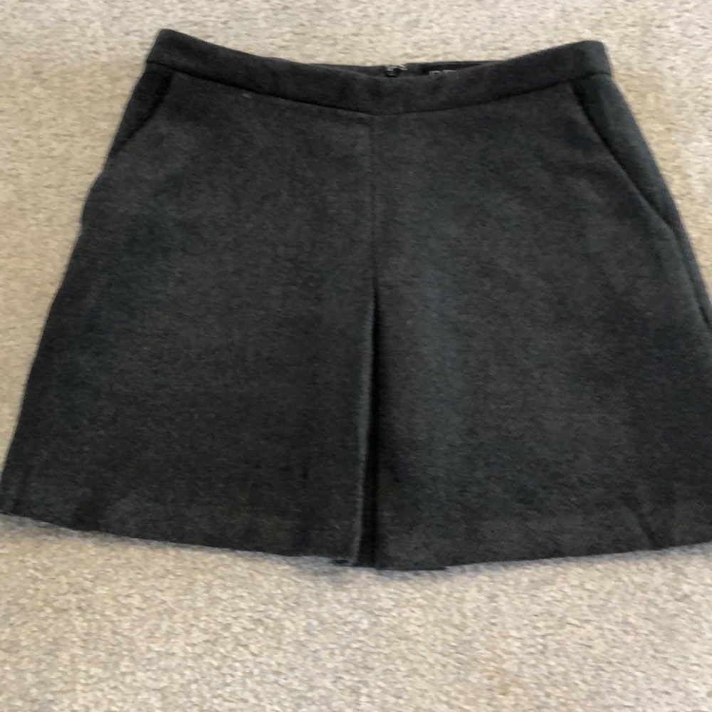 Short pleated grey skirt.